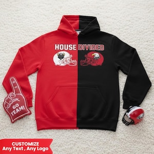 Puede incluir: Una sudadera con capucha roja y negra con el texto "HOUSE DIVIDED" y gráficos de cascos de fútbol. Un dedo de espuma rojo con "GO TEAM!" está a la izquierda. Un pequeño casco de fútbol está a la derecha. El banner inferior dice "PERSONALIZA Cualquier texto, Cualquier logo".