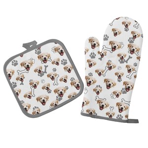 Puede incluir: Un juego de dos guantes de horno blancos con un patrón de caras de perro y huellas de patas. Los guantes están ribeteados con un borde gris.