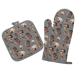 May include: A set of two gray oven mitts with a repeating pattern of faces of people and dogs. The mitts are made of a soft, heat-resistant material.