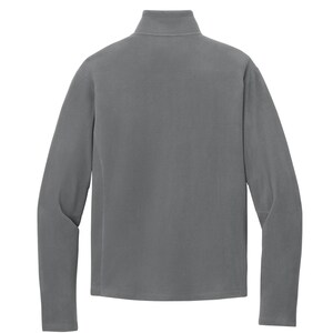 May include: A gray fleece pullover with a mock neck collar and long sleeves. The back view of the garment shows a smooth, solid color and a simple, classic design. The fleece material appears soft and comfortable.