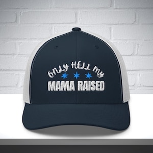 Könnte beinhalten: Marineblaue und weiße Trucker-Mütze mit dem gestickten Text "only hell my MAMA RAISED" in Weiß, mit drei blauen Sternen. Die Mütze hat einen gebogenen Schirm und eine Mesh-Rückseite.