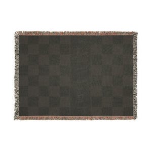 May include: A dark grey woven throw blanket with a chequered pattern. The blanket has a fringed edge with a mix of colours, including red, grey, and white. The blanket is rectangular and appears to be made of a soft material.