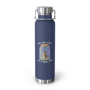 Puede incluir: Una botella de agua de acero inoxidable en azul marino mate con tapa y asa de metal plateado. El frente presenta un gráfico de una pequeña criatura con un sombrero de rayas amarillas y negras dentro de un frasco, con el texto YOU ARE A BUG IN A BUG JAR.