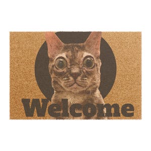 以下が含まれることがあります： 黒い円の前に猫の顔が描かれた長方形のドアマット。 猫は大きく表現力豊かな目を持ち、茶色とタン色の毛皮をしています。 「Welcome」の文字がマットの下部に暗い文字で印刷されています。 マットは明るい茶色の素材で作られています。