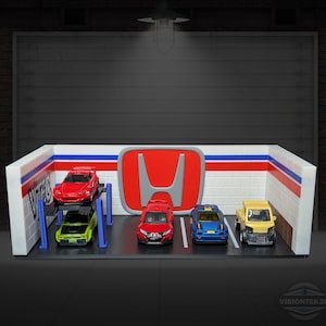 May include: A miniature garage scene featuring a red Honda logo and several toy cars. The cars include a red sports car on a lift, a green sports car, a red car, a blue car, and a yellow truck.