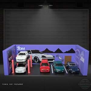 May include: A miniature JDM garage diorama with a purple backdrop, featuring a large car graphic and the text "eat sleep JDM". Five model cars in white, red, and blue are parked inside. The text "cars not included" is at the bottom.