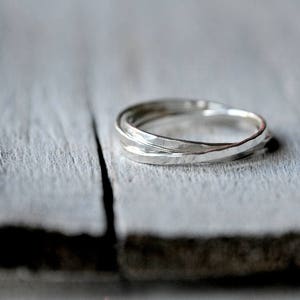 Peut inclure: Une bague en argent avec une texture martelée, composée de deux bandes entrelacées.