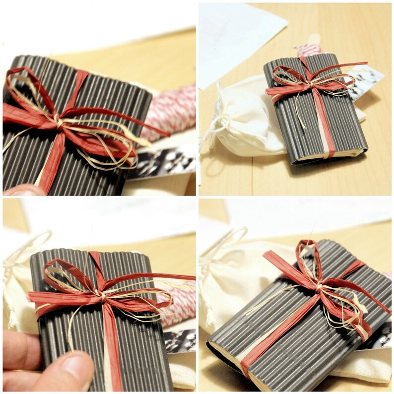 May include: A black and gray striped notebook with a red and beige ribbon tied around it. The notebook is sitting on a white surface.