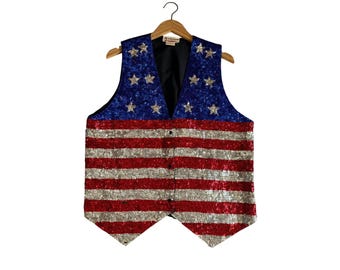 May include: A sleeveless vest covered in sequins featuring a blue upper section with silver star appliques and a lower section with alternating horizontal red and silver stripes. The garment has a black interior lining and a front button closure.