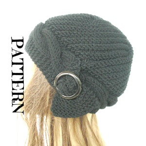 May include: A black knitted beanie with a large, round, black metal accent on the side. The beanie is slouchy and has a textured knit.