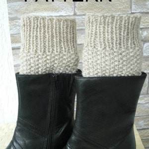 Puede incluir: Un par de botas de cuero negro con polainas de punto beige. Las polainas están hechas con un punto de tejido sencillo.