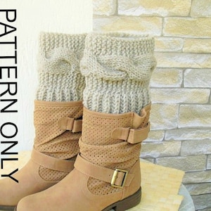 May include: A pair of brown leather boots with cable knit beige boot cuffs. The boots have a buckle detail and a pointed toe.