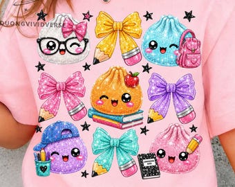 May include: A light pink t-shirt featuring a graphic print of various cartoon characters, including dumplings with faces, colorful bows, pencils, books, and a small backpack, all accented with black stars and glittery textures.
