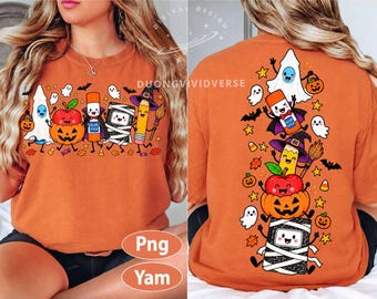May include: An orange t-shirt featuring a graphic print of cartoon school supplies dressed for Halloween, including a ghost, a jack-o'-lantern, a glue stick, a mummy notebook, and a pencil with a witch hat, surrounded by bats, stars, and candy.