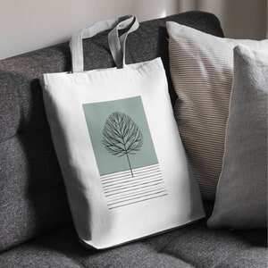 Peut inclure: Sac fourre-tout en toile blanche avec un design minimaliste représentant une silhouette noire d'arbre sur un fond bleu clair avec des lignes horizontales blanches.