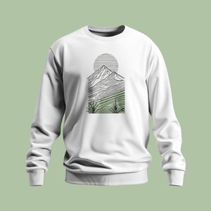 Peut inclure: Sweat-shirt blanc avec un dessin au trait noir et vert d'une chaîne de montagnes avec un soleil au-dessus.