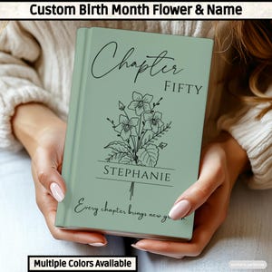 May include: A sage green hardcover book featuring a black line art illustration of a flower bouquet. The text reads Chapter FIFTY, the name STEPHANIE, and the phrase Every chapter brings new growth. The cover has a smooth, matte finish.