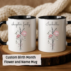 May include: Two white ceramic mugs with black handles and rims. One mug reads "chapter forty" and the other reads "Isabella". Both mugs feature a floral design with pink flowers and green leaves. The text "Custom Birth Month Flower and Name Mug" is below.