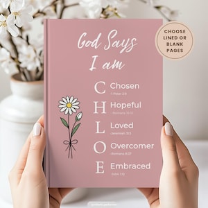 Puede incluir: Un diario de color rosa polvoriento con el texto God Says I am y el nombre CHLOE alineado verticalmente con descriptores bíblicos: Chosen, Hopeful, Loved, Overcomer y Embraced. Una ilustración de una margarita blanca aparece en la portada.