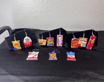 May include: A set of 10 pairs of earrings featuring various popular snack foods, including Cheetos, Skittles, Ruffle's, and Takis. The earrings are made of polymer clay and are designed to look like the actual snack food packaging.