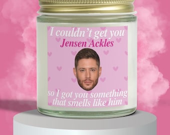 Op de afbeelding: Geurkaars in een glazen pot met een gouden deksel. Het etiket bevat de tekst "I couldn't get you Jensen Ackles, so I got you something that smells like him" met een foto van Jensen Ackles en roze hartjes.