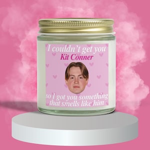 May include: A scented candle in a glass jar with a gold lid. The label features the text "I couldn't get you Kit Conner so I got you something that smells like him" with a photo of a young man and pink hearts.