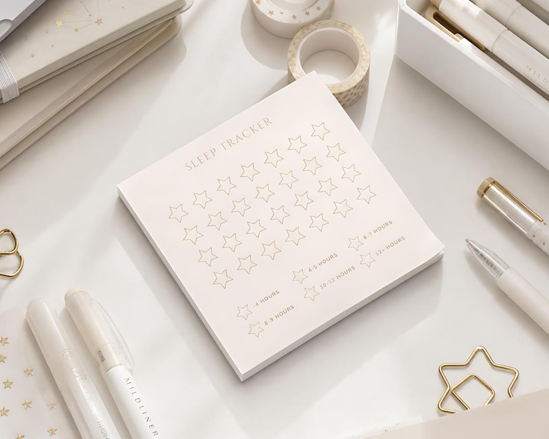 May include: A square notepad with a light cream background featuring the text SLEEP TRACKER at the top. The page contains a grid of outlined stars for tracking sleep, with additional star icons labeled with hour ranges from <4 hours to 12+ hours.