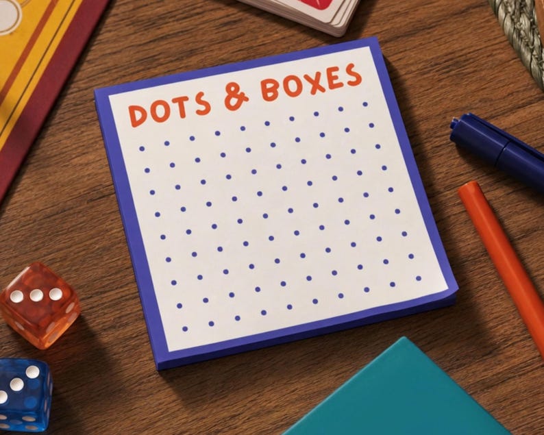 K&ouml;nnte beinhalten: Ein quadratischer Notizblock mit wei&szlig;em Hintergrund und blauem Rand, der oben den orangefarbenen Text DOTS & BOXES und ein auf die Seite gedrucktes Raster aus blauen Punkten aufweist. Der Notizblock liegt auf einer Holzoberfl&auml;che mit Spielsteinen.