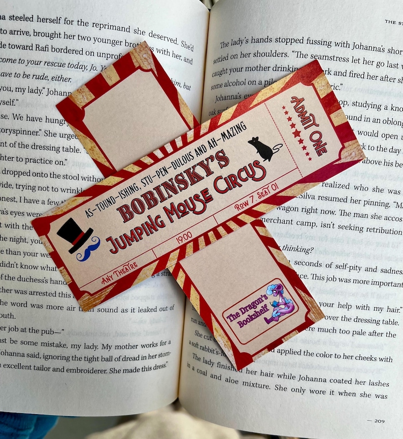 Pode incluir: Um marcador de livros de estilo vintage com um design de bilhete para o "Bobinsky's Jumping Mouse Circus". O bilhete &eacute; vermelho e creme com uma ilustra&ccedil;&atilde;o de cartola e bigode. Inclui o texto "Admit One" e o log&oacute;tipo "The Dragon's Bookshelf".