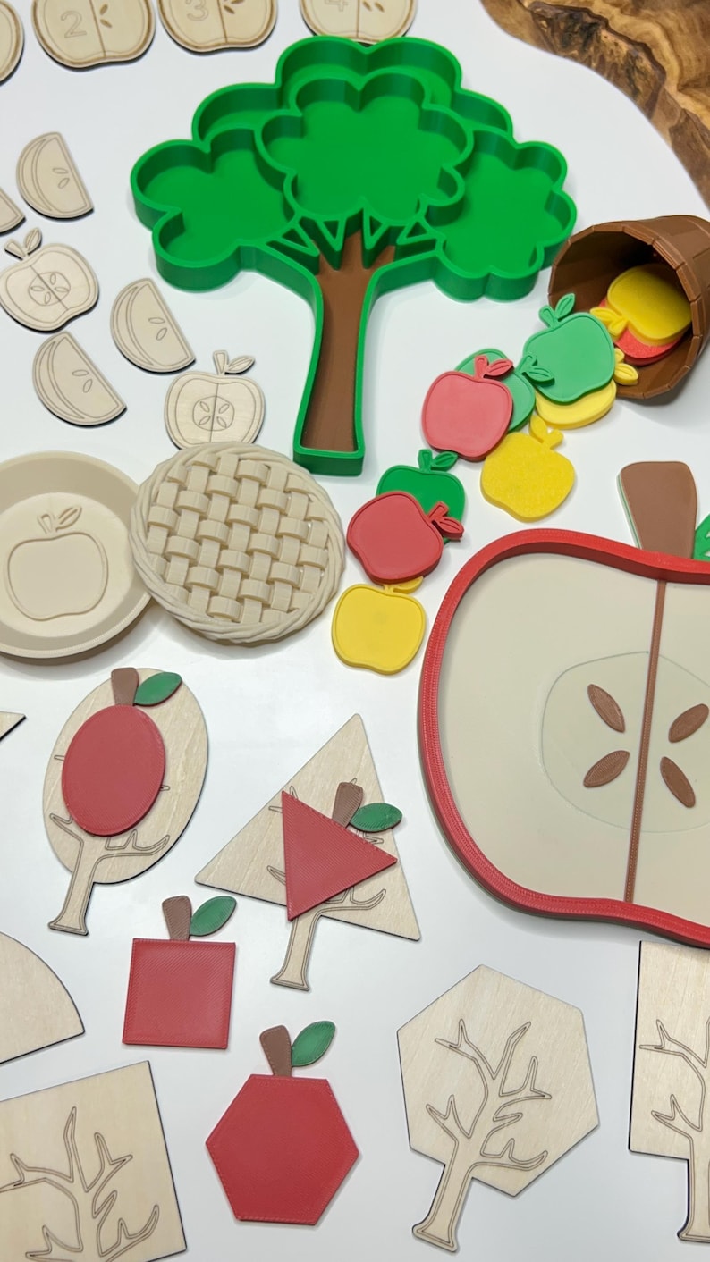 May include: A collection of wooden and colorful apple-themed educational toys. Includes apple slices, a pie crust, a tree, and various apple shapes in red, green, and yellow. The toys are designed for learning and play.