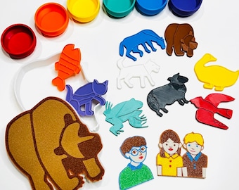 May include: A collection of colorful felt shapes, including animals, people, and round lids. The shapes are in various colors such as red, orange, yellow, green, blue, and brown. The image is taken from a top-down perspective.