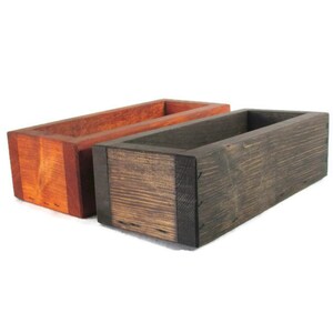 May include: Two wooden boxes, one stained a dark brown and the other a reddish brown. Both boxes are rectangular and have a simple design.