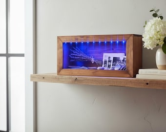 Caja de sombras iluminada montada en la pared.