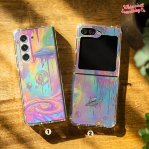 May include: Two phone cases featuring a galaxy and dripping paint design. The case on the left is for a standard phone and the case on the right is for a foldable phone. Both cases have a holographic iridescent finish.