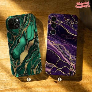 May include: Two phone cases with marble designs. One is green with gold veining, the other is purple with gold veining. The cases are numbered 1 and 2. The brand name "Whimsical Something Co" is in the top right corner.