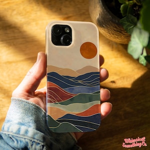 May include: A phone case with a colorful abstract design featuring a sunset over a mountain range. The design is in shades of blue, green, red, and orange.