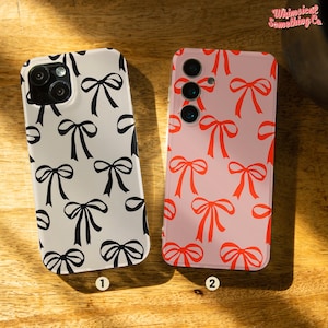 May include: Two phone cases with a bow pattern. The case on the left is white with black bows. The case on the right is pink with red bows. Both cases have a camera cutout.