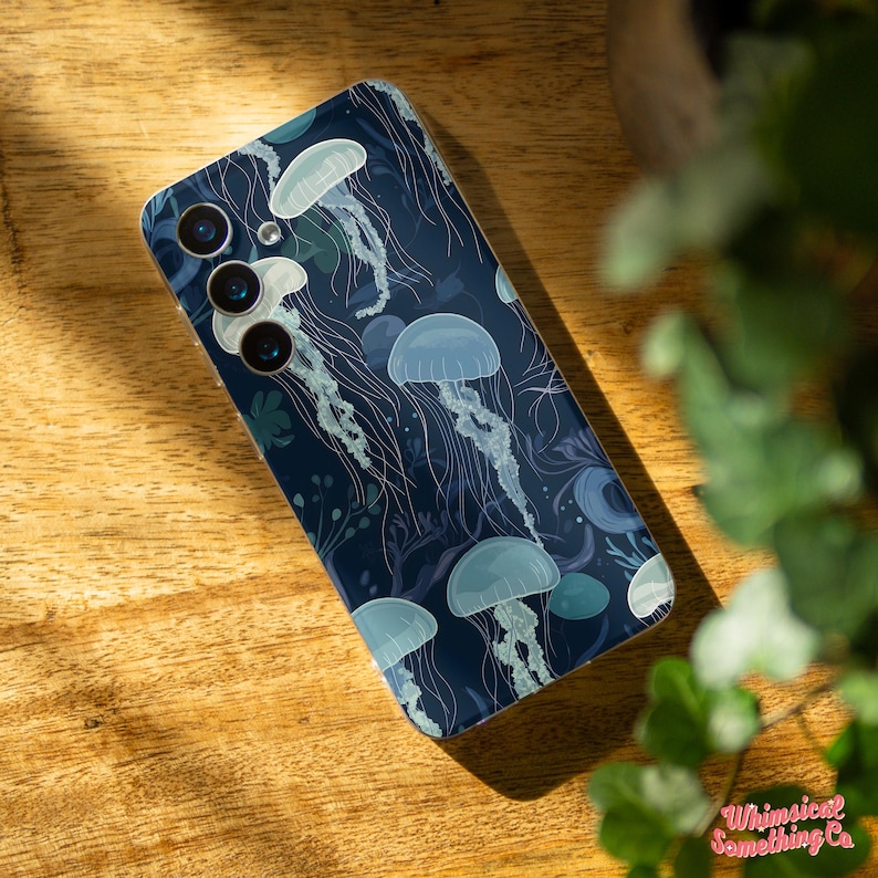May include: A dark blue phone case with a design of white jellyfish on a dark blue background.