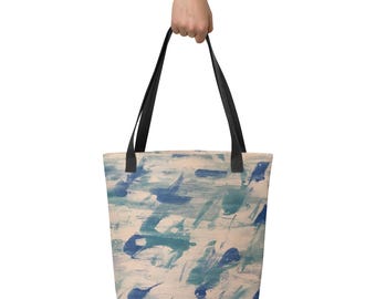 May include: A beige tote bag with black handles and an abstract design featuring blue and green brushstrokes.