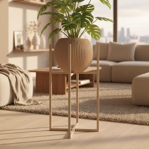 Könnte beinhalten: Ein Pflanzenständer aus Holz mit einem kugelförmigen, gerippten Pflanzgefäß, das eine grüne Blattpflanze enthält. Der Ständer hat eine quadratische Rahmenbasis und eine kreuzförmige Stütze. Der Pflanzenständer befindet sich in einem hellen Wohnzimmer.