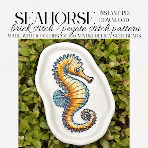 Puede incluir: Un plato blanco de forma irregular contiene un diseño de caballito de mar con cuentas. El caballito de mar es principalmente naranja y amarillo con detalles azules, creado con técnicas de punto de ladrillo y punto peyote. El texto de la imagen dice "SEAHORSE" y "brick stitch / peyote stitch pattern".