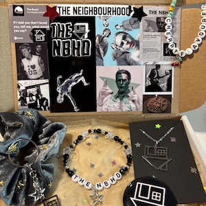 Op de afbeelding: Cadeaubox met merchandise van de band "The Neighbourhood". Inclusief een kralenarmband, ketting, sleutelhanger, scrunchie en een button. De doos bevat ook afbeeldingen en tekst gerelateerd aan de band.