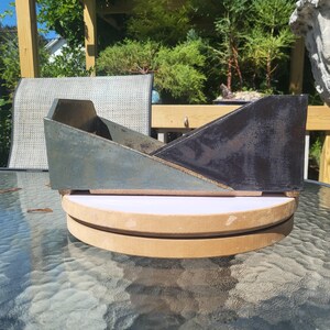 May include: A rectangular ceramic bonsai pot featuring a distinct slanted profile. The left side displays a matte, muted blue-grey finish, while the right side is finished in a glossy, dark black glaze. The base is a light, unglazed tan clay.