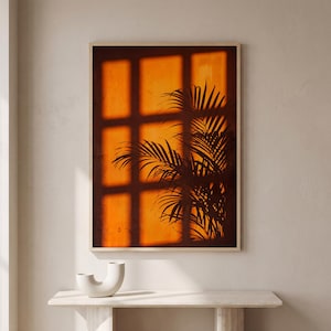 Arte mural con la sombra de una hoja de palmera naranja, póster de luz de ventana al atardecer, silueta de planta tropical, fotografía de la hora dorada, decoración bohemia para el hogar