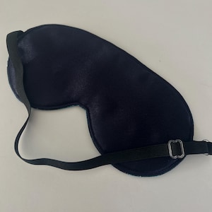 May include: A black sleep mask with an adjustable elastic strap. The mask is made of a soft, comfortable material and is designed to block out light.