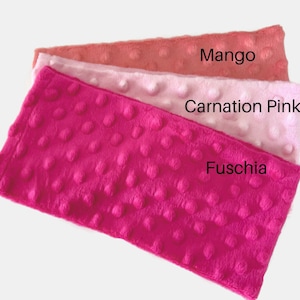Puede incluir: Tres muestras de tela en diferentes tonos de rosa. La muestra superior es de color naranja claro y est&aacute; etiquetada como "Mango". La muestra del medio es de color rosa claro y est&aacute; etiquetada como "Carnation Pink". La muestra inferior es de color fucsia brillante y est&aacute; etiquetada como "Fuschia".