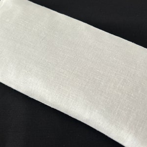 a white pillow sitting on top of a black table