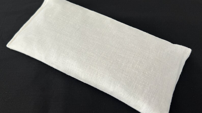 a white pillow sitting on top of a black table