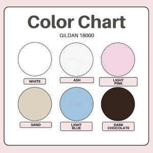 May include: A Gildan 18000 colour chart featuring six circular swatches labelled White, Ash, Light Pink, Sand, Light Blue, and Dark Chocolate. The chart displays these colour options in two rows of three, providing a clear visual reference for fabric shades.
