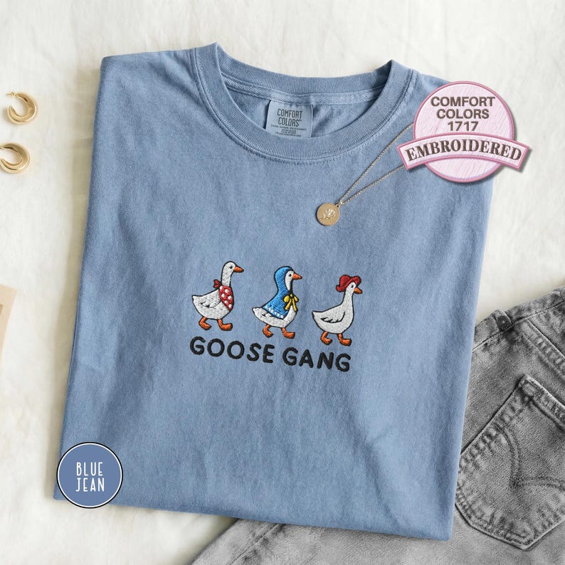 Embroidered goose gang t-shirt featuring three cute geese with colorful scarves stitched on a soft blue Comfort Colors tee, playful animal embroidery casual top for everyday wear or group gift